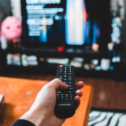 person holding black remote control