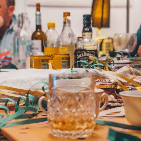 drinking glasses and wine bottles on wooden surface