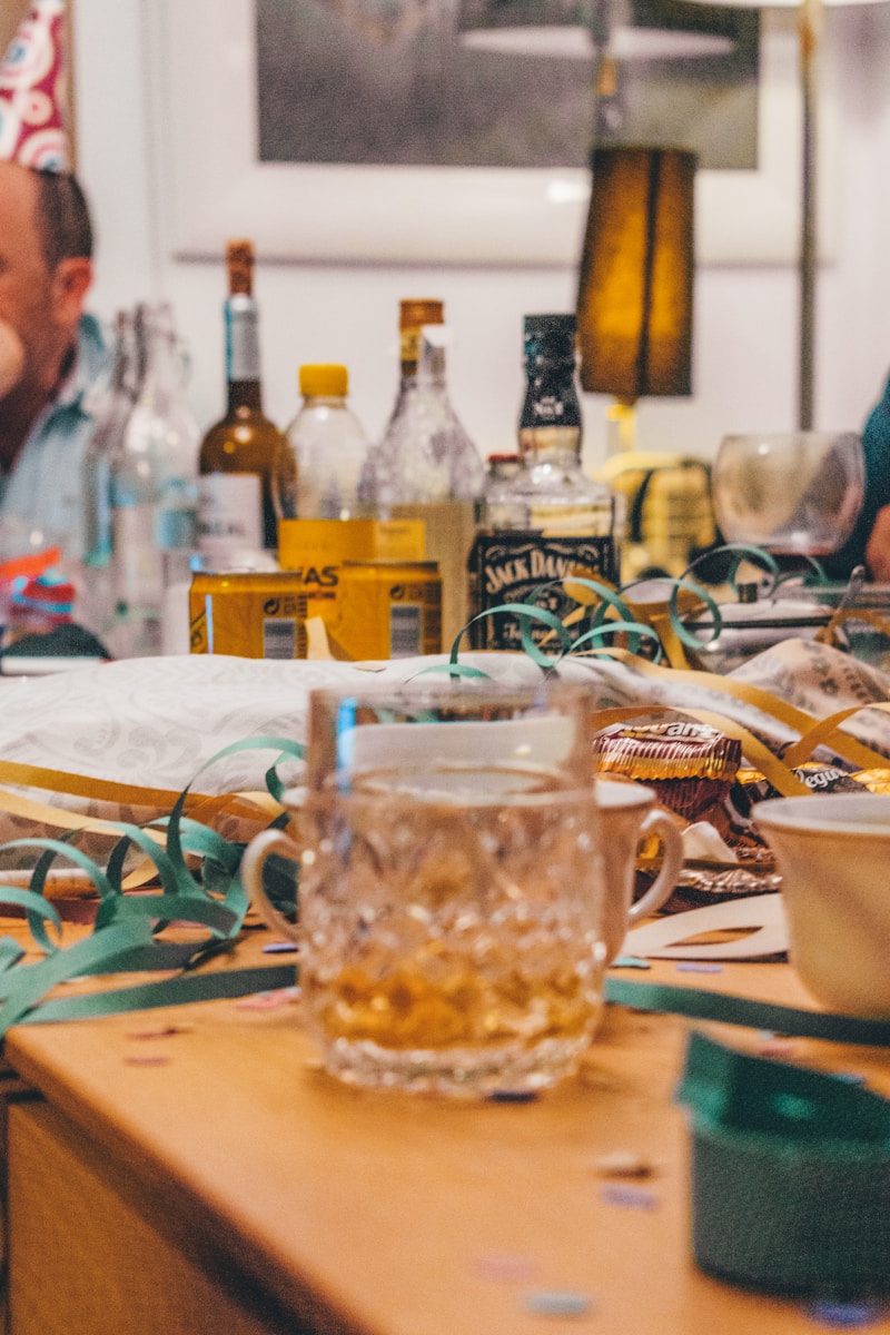 drinking glasses and wine bottles on wooden surface