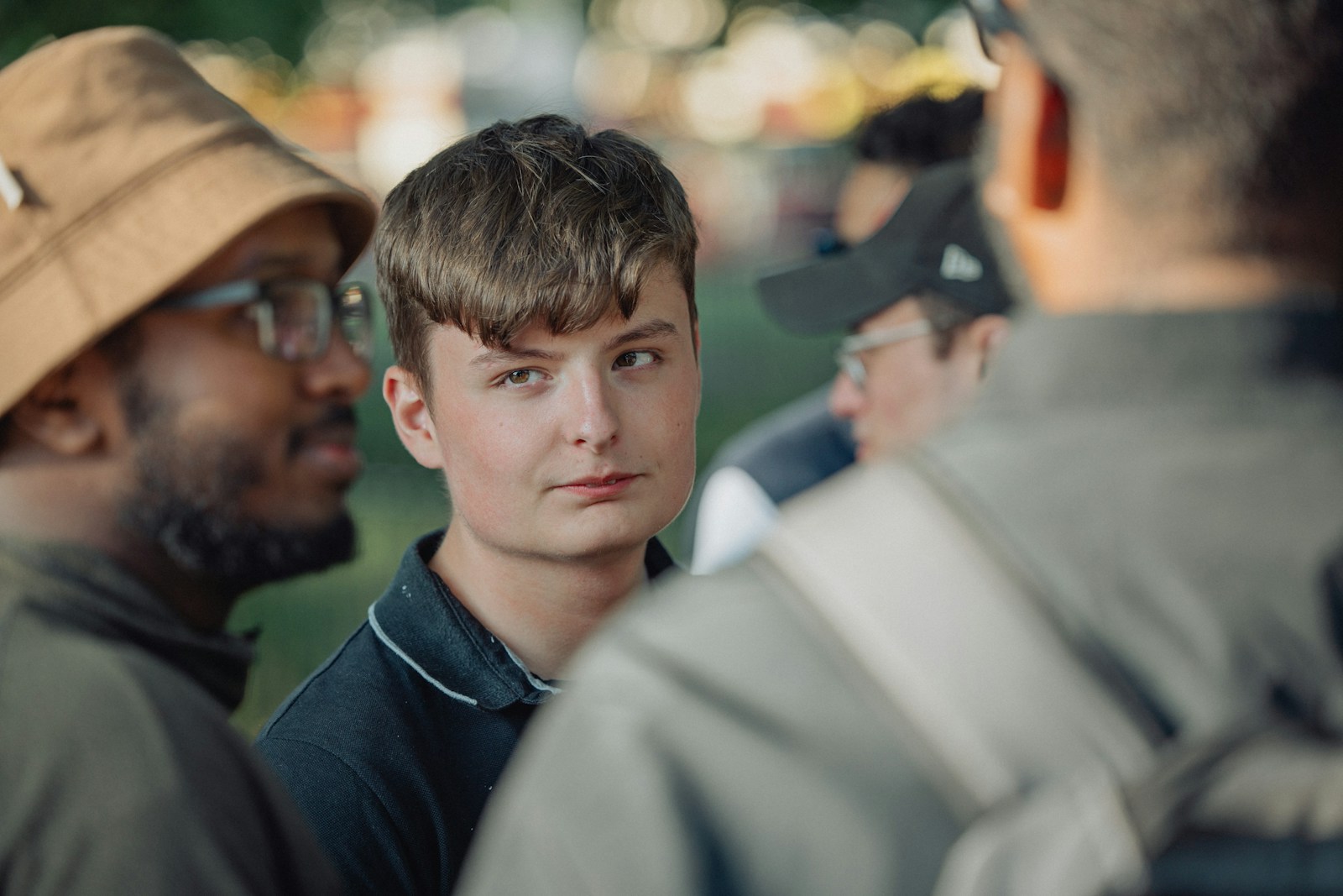 A young man looks at someone nearby.