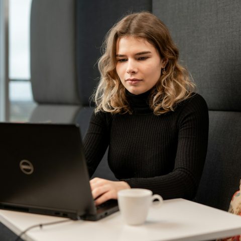 a woman sitting at a table with a laptop