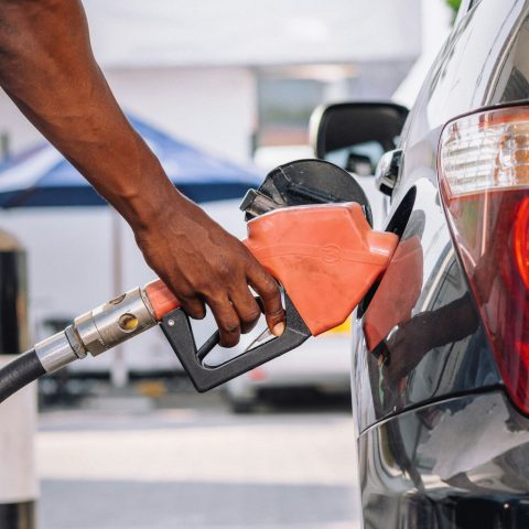 a man pumping gas into his car at a gas station