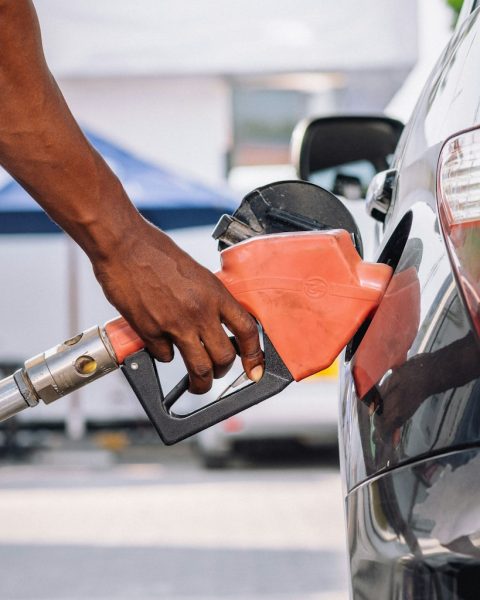 a man pumping gas into his car at a gas station