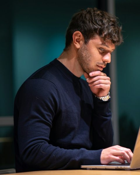man in black long sleeve shirt sitting in front of macbook