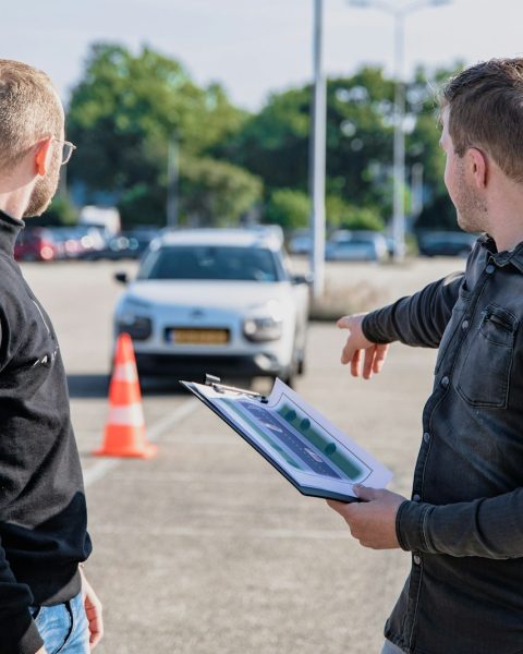 man in black jacket holding blue tablet computer