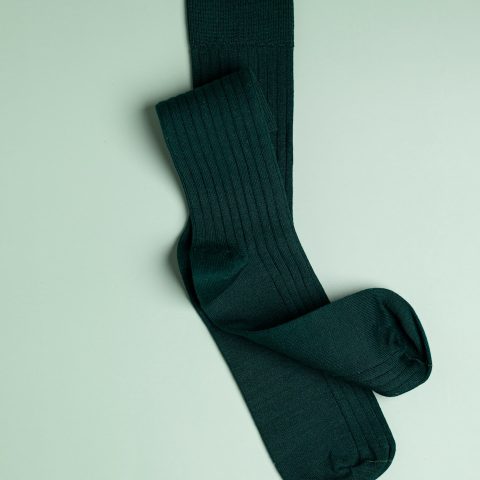 a pair of green socks laying on top of a white surface