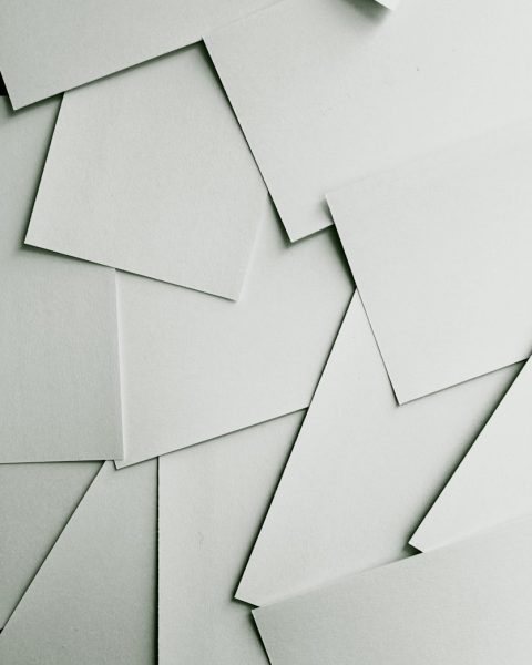 Scattered sheets of white paper covering the entire frame