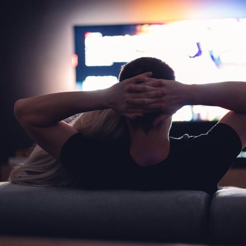 Twee mensen kijken samen naar een film op de bank tijdens een avond thuis