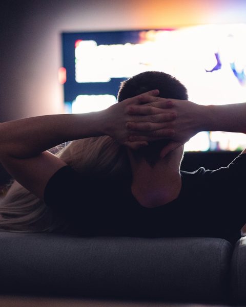 Twee mensen kijken samen naar een film op de bank tijdens een avond thuis