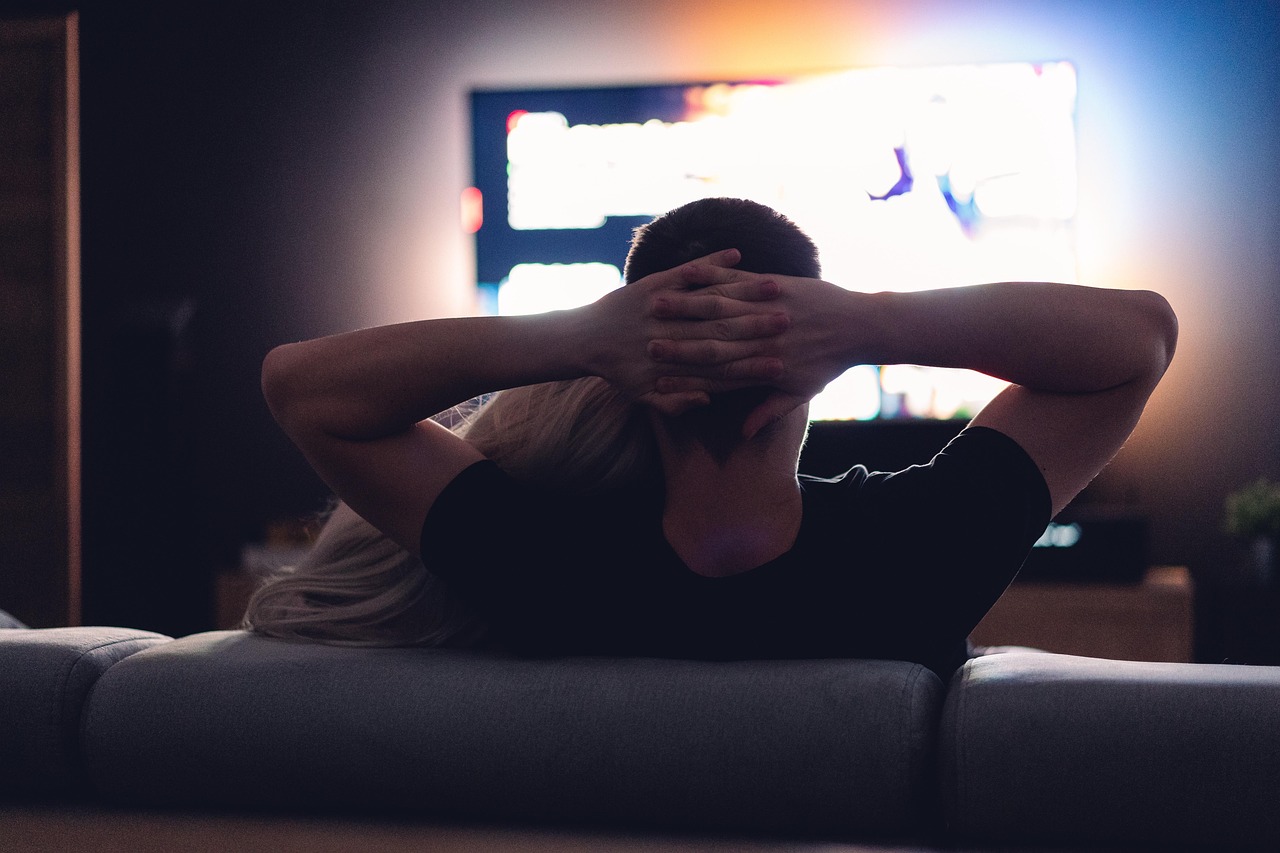 Twee mensen kijken samen naar een film op de bank tijdens een avond thuis