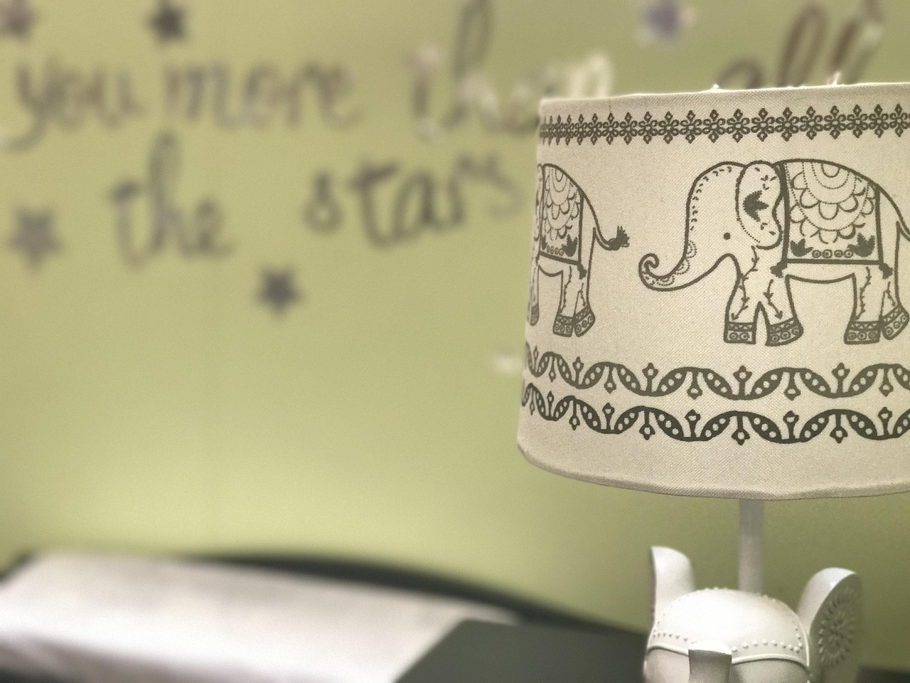 Pastelkleurige babykamer met ledikant, commode en zachte verlichting