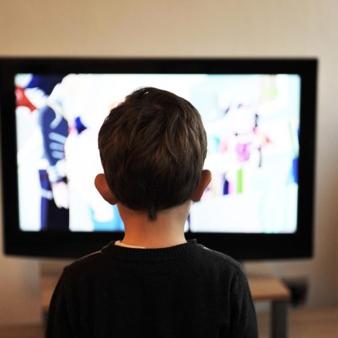 Persoon die comfortabel een film kijkt op televisie in een gezellige woonkamer