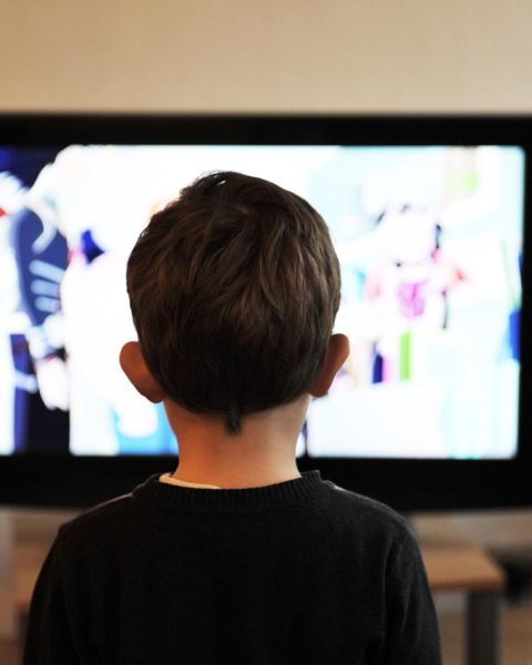 Persoon die comfortabel een film kijkt op televisie in een gezellige woonkamer