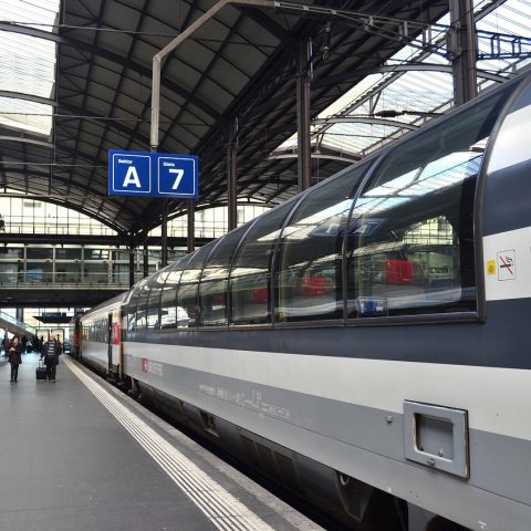 Reizigers met koffers op een Belgisch treinstation richting luchthaven