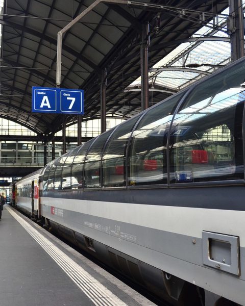 Reizigers met koffers op een Belgisch treinstation richting luchthaven