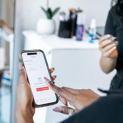 Hands holding a smartphone displaying a booking app.