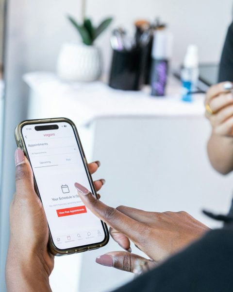Hands holding a smartphone displaying a booking app.