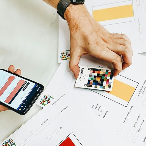 person holding iphone on white printer paper