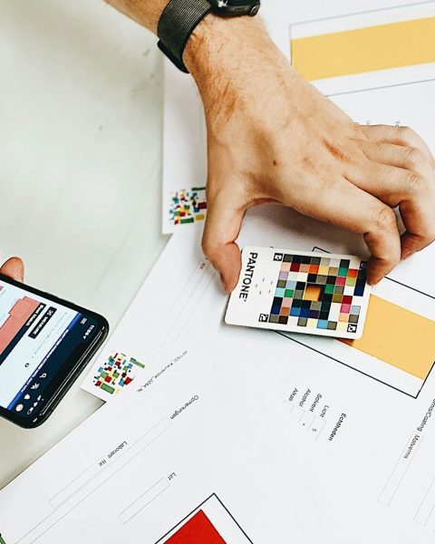 person holding iphone on white printer paper