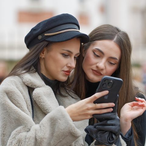 Gezin dat samen hun budget bekijkt op een smartphone aan de keukentafel