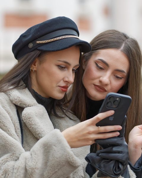 Gezin dat samen hun budget bekijkt op een smartphone aan de keukentafel
