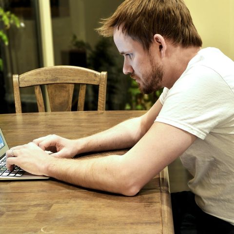 Een volwassen professional die achter een laptop studeert voor een nieuwe carrière