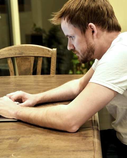 Een volwassen professional die achter een laptop studeert voor een nieuwe carrière