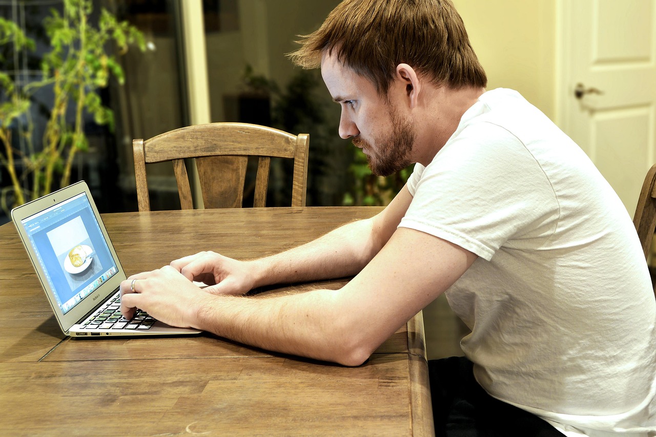 Een volwassen professional die achter een laptop studeert voor een nieuwe carrière