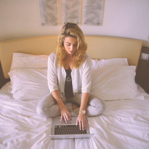 Persoon kijkt gefrustreerd naar laptop terwijl hij online probeert in te loggen