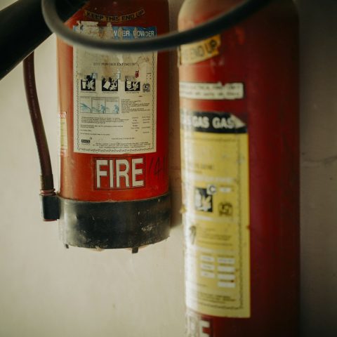 Two red fire extinguishers hung on wall