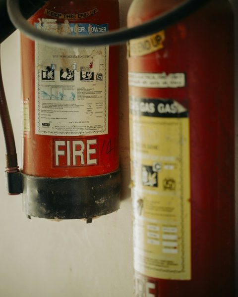 Two red fire extinguishers hung on wall