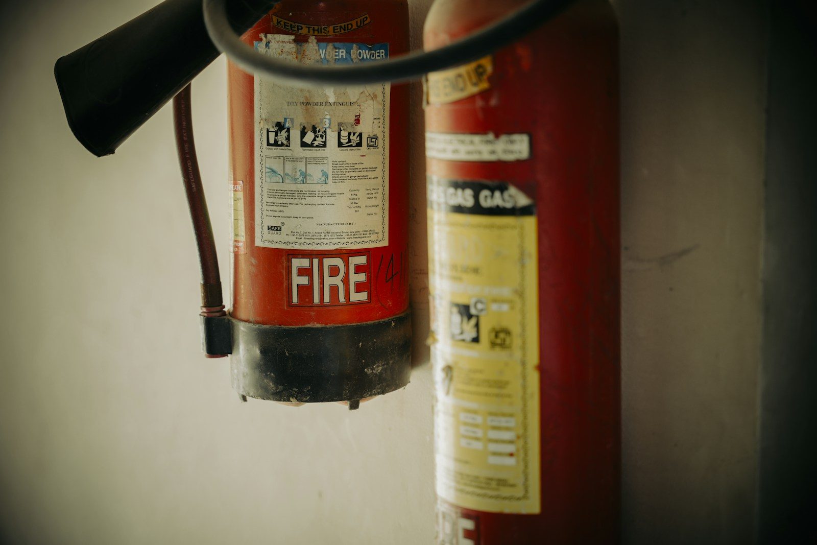 Two red fire extinguishers hung on wall