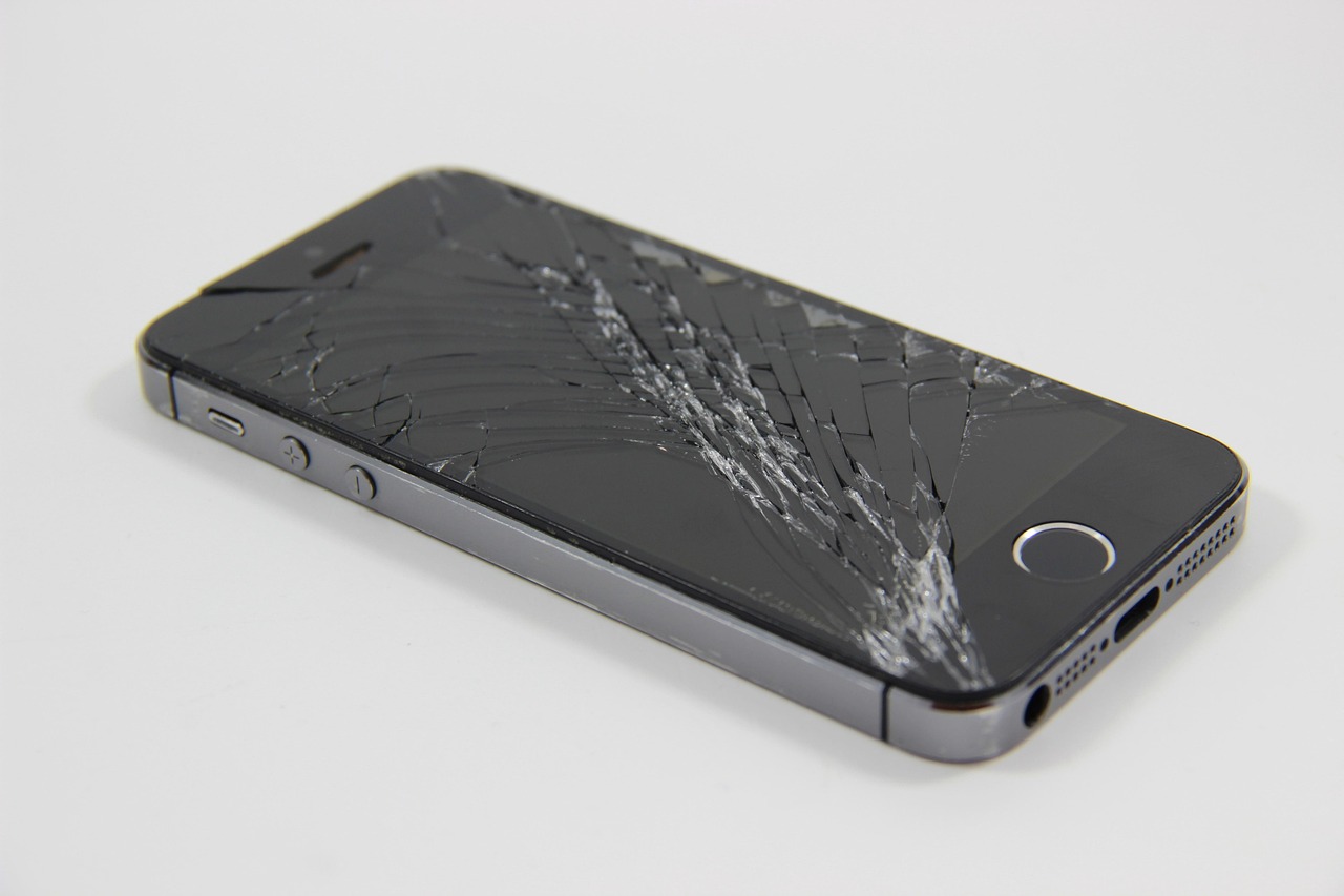 Een smartphone met een gebarsten scherm op een werkbank bij een hersteller