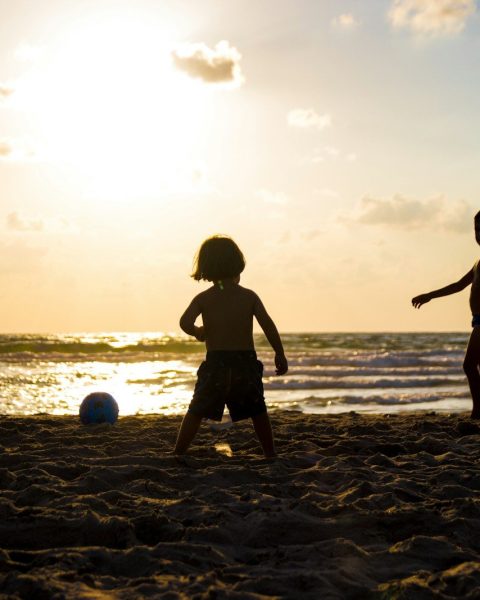 silhouette of three children on beach
