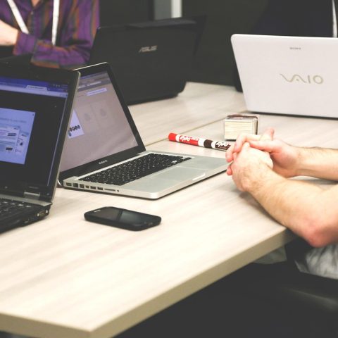 Een klein team in een open kantoorruimte tijdens een informeel overleg bij een startup