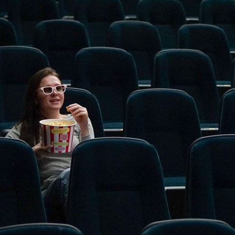 Vrouw kijkt ontspannen naar een film op de bank