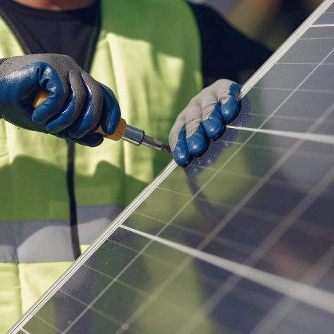 Technicus installeert zonnepanelen op een dak tijdens een renovatieproject