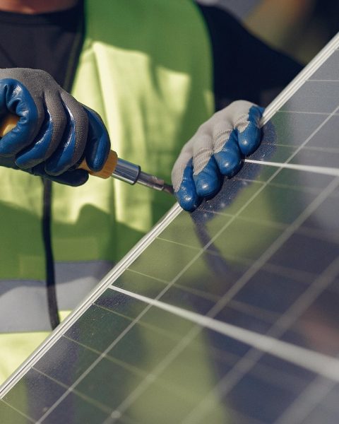 Technicus installeert zonnepanelen op een dak tijdens een renovatieproject