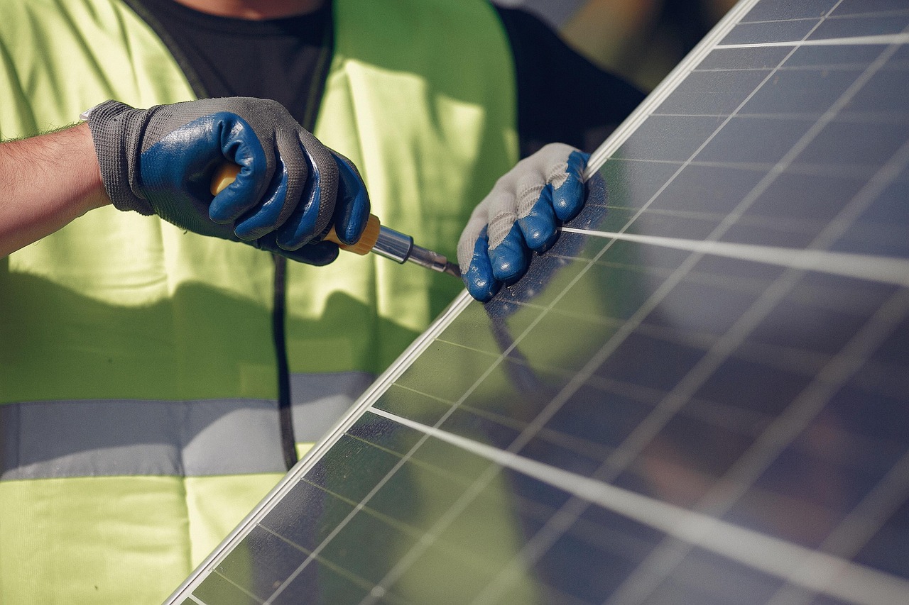 Technicus installeert zonnepanelen op een dak tijdens een renovatieproject