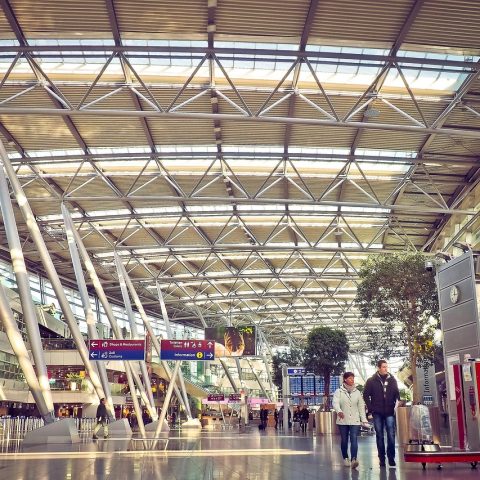 Drukke vertrekhal in een grote Europese luchthaven met reizigers en handbagage