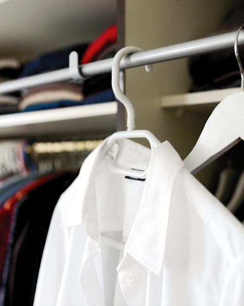 Een nette herfstgarderobe met gelaagde kleding in warme neutrale tinten zoals beige, roest en donkerblauw