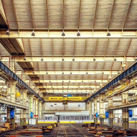 Moderne coworkingspace in een industrieel gebouw met grote ramen en open werktafels