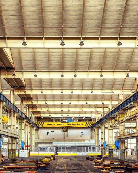 Moderne coworkingspace in een industrieel gebouw met grote ramen en open werktafels