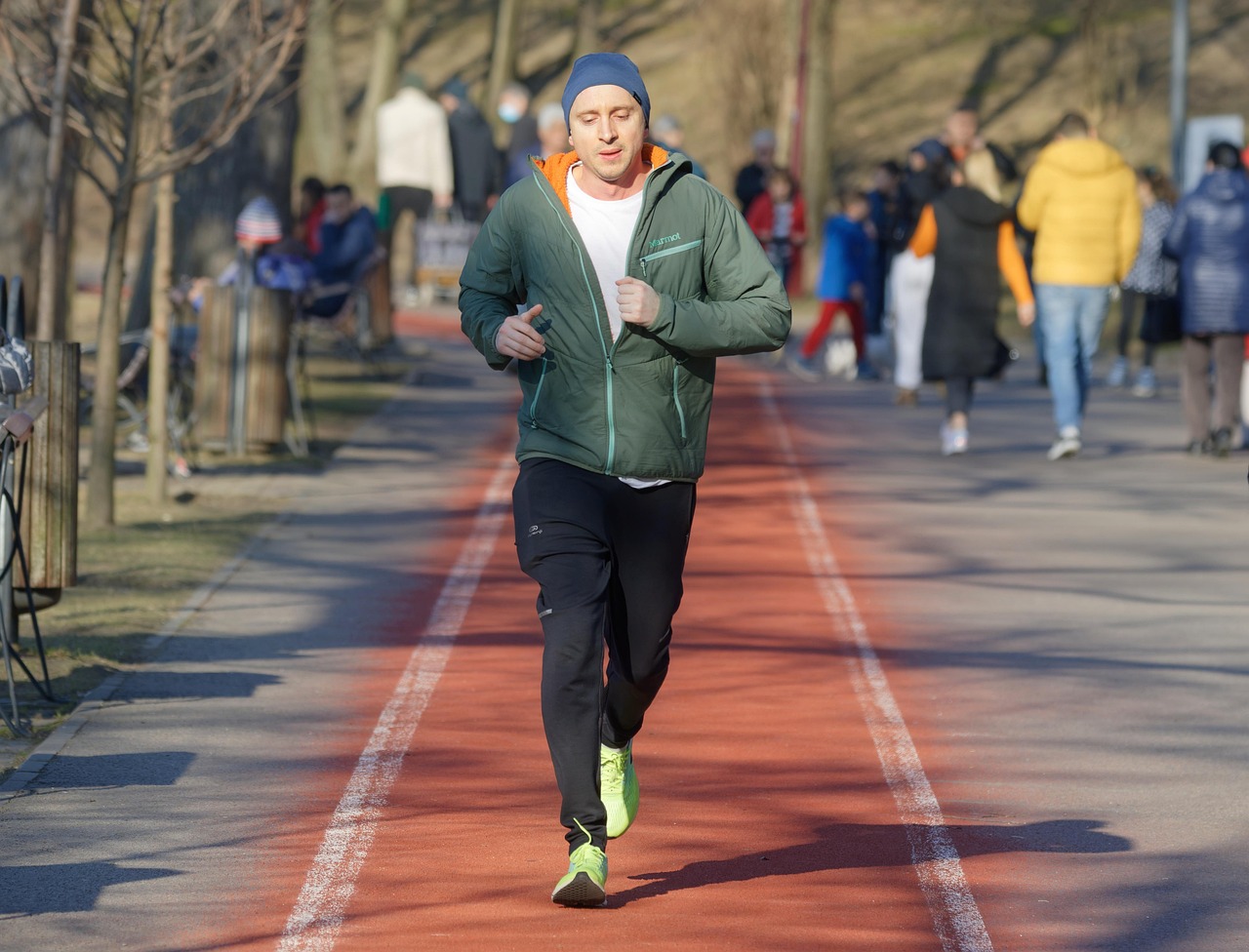 Een man loopt rustig door een park op een ochtend, als metafoor voor Ruben Van Gucht die sport gebruikt om tot rust te komen buiten zijn televisiewerk.