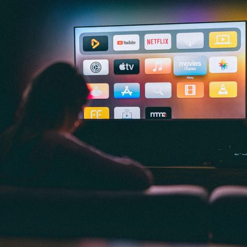 Gezin op de bank dat samen naar een streamingdienst kijkt op de televisie