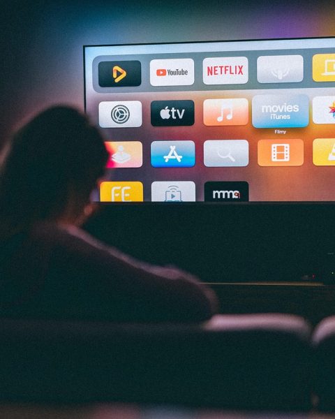 Gezin op de bank dat samen naar een streamingdienst kijkt op de televisie