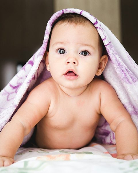 baby under purple blanket