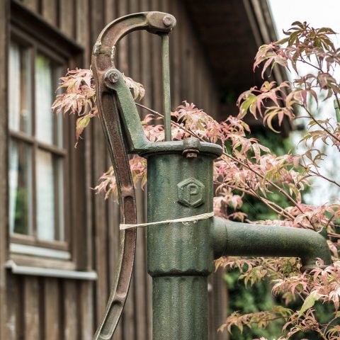 Buitenunit van een warmtepomp naast een Belgische woning